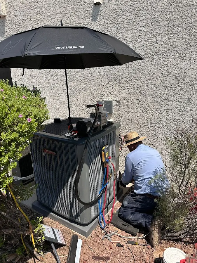 HVAC technician performing outdoor AC maintenance in Ennis